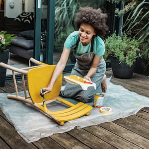  woman on the patio painting a wood chair